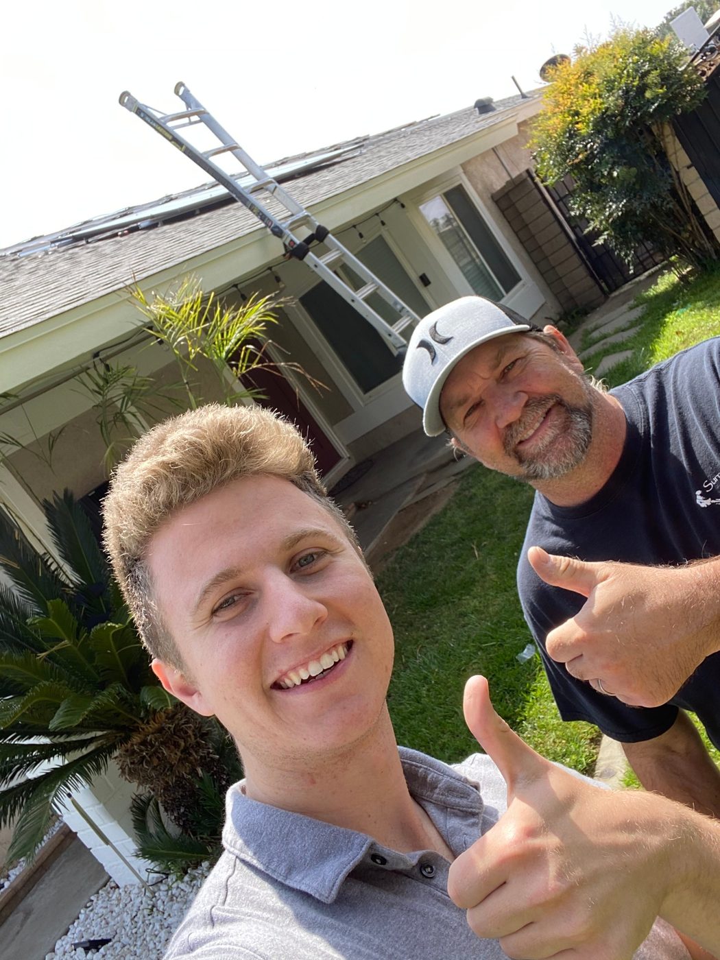 Conner Leeb with a homeowner outside his newly solar-equipped home